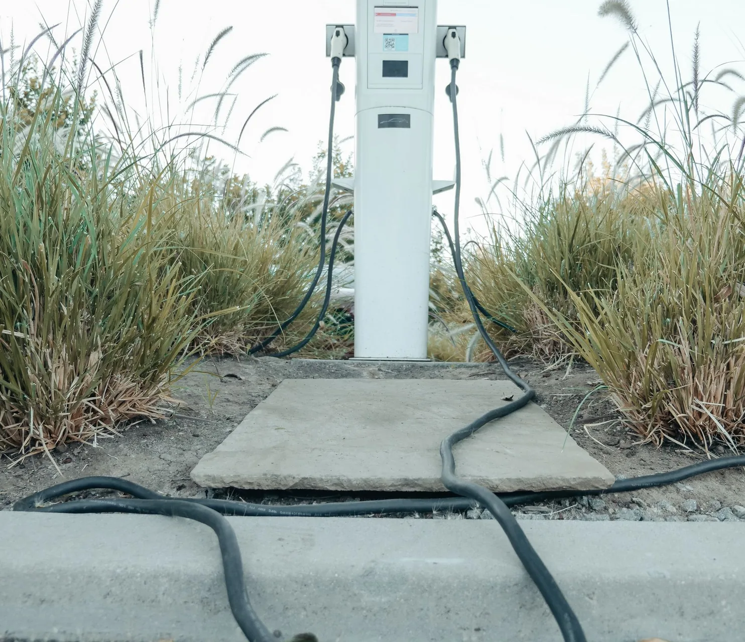 Outdoor electric vehicle charging station with charging cables