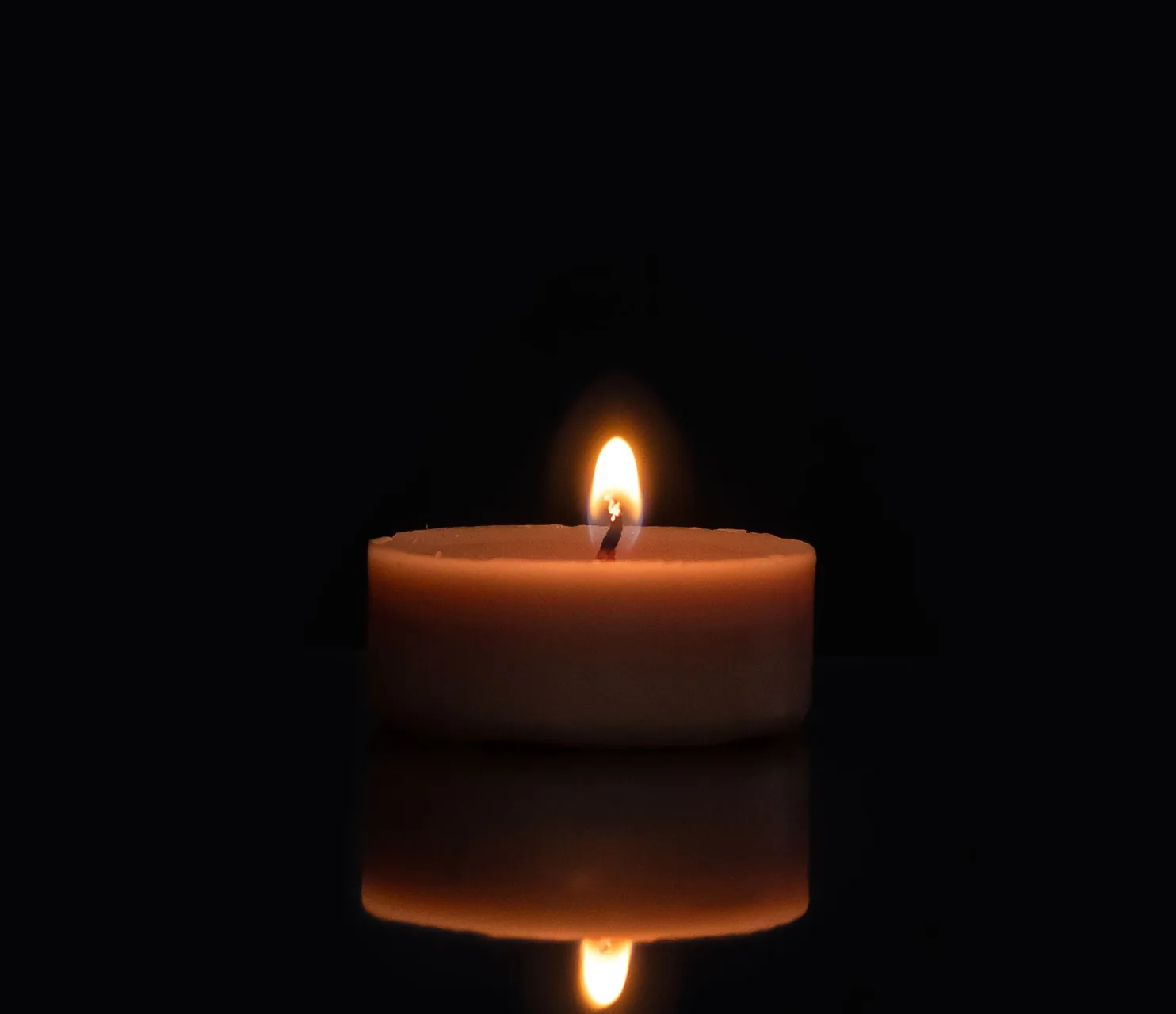 A candle illuminating a dark room